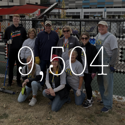 2024 employee community volunteer hours 9,504. Image of 9 CRBT volunteers smiling at camera in front of the nonprofit building, The Arc of East Central Iowa.
