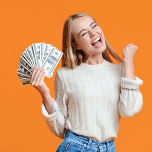 Young blonde woman excited holding cash in hand