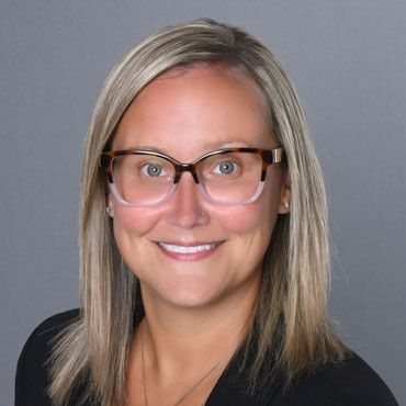 Amanda Brade headshot, blonde with glasses